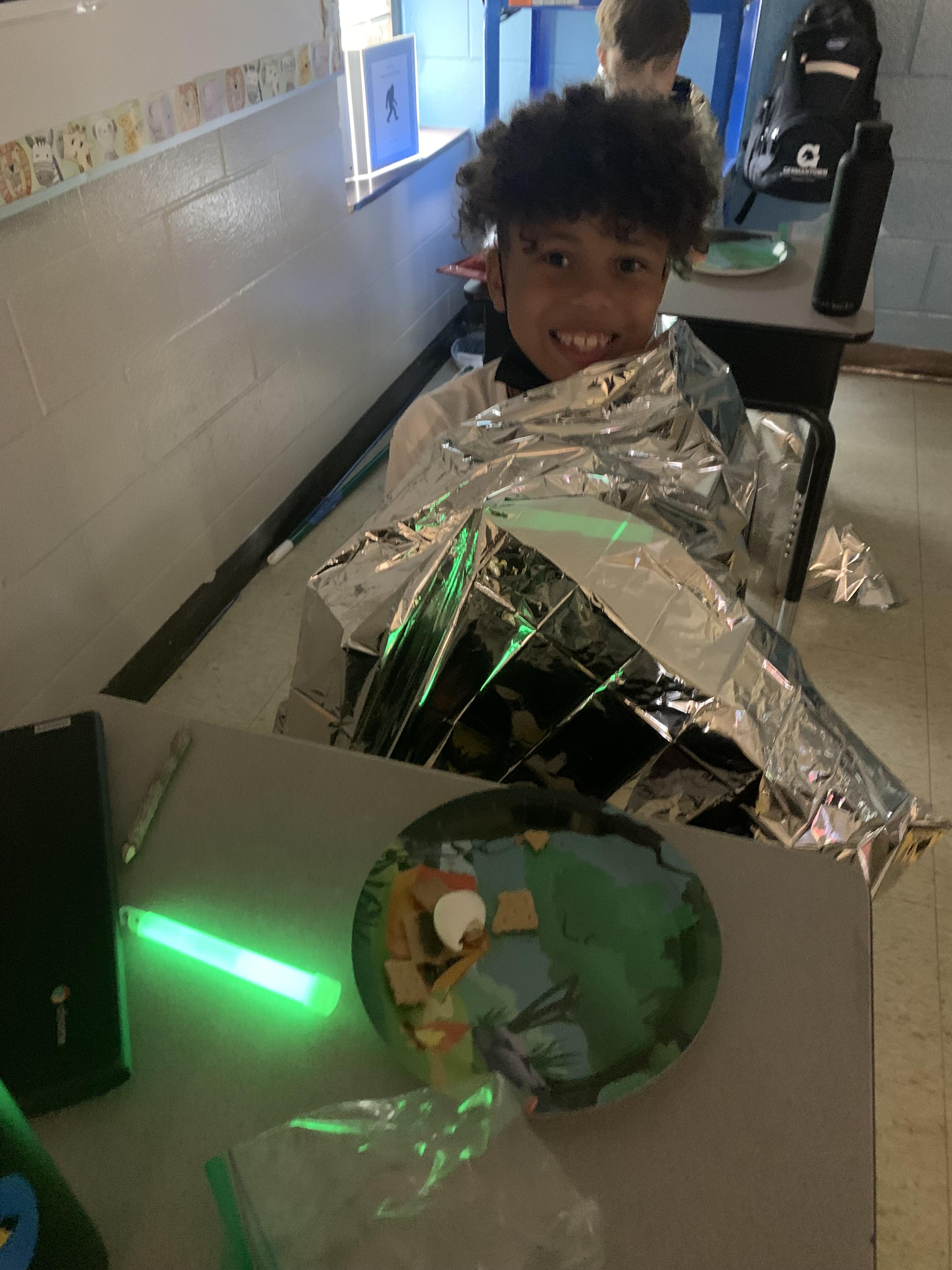 Student wrapped up in foil for a class camp out